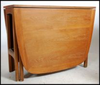 A 1970's 20th century rare Nathan teak wood drop leaf dining table. The full length drop leaves