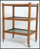 A vintage mid 20th century three tier tri colour oak drinks trolley having tapered legs raised on