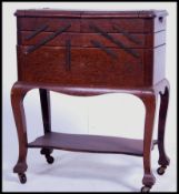 A good mid century oak sewing box with articulated action having ebonised bracket work. All raised