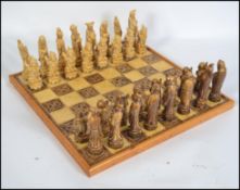 A 20th century Oriental resin chess set complete with heavy tile board with white blank squares