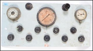 A 20th century industrial instrument panel having applied pressure gauges light fittings and