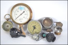 A collection of industrial and motoring relating dials and gauges to include pressure gauge,