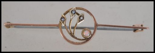 An Art Nouveau 9ct gold opal and pearl brooch having a c clasp. Marked 9ct tests 9ct gold.