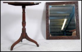 A 19th century country oak tilt top wine table being raised on tripod base having an oak planked top