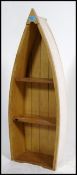 A 20th century small bookshelf in the form of a rowing boat. Standing on it's end with shelved