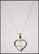 A 9ct gold heart pendant necklace and chain. The f