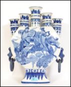 A large Chinese Kang-xi blue and white five neck moon Guan type vase flask bearing mythical scenes -