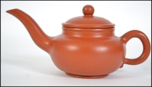 A Chinese terracotta yi-xing teapot with an extra
