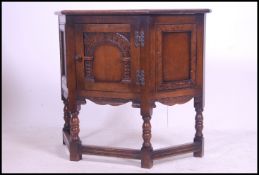An Ercol oak 'Colonial ' hall cabinet raised on block and turned legs united by stretchers having