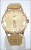 An 18ct gold vintage gentlemans Longines wristwatch having a baton numeral face with faceted hands