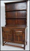 A 20th century Jacobean revival solid oak sideboard dresser. Raised on squared legs with