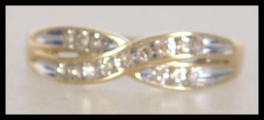 A hallmarked 9ct gold and diamond kiss crossover ring. Weight 2.6g. Diamonds approx 15pts. Size T.