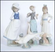 A collection of porcelain Lladro and Nao figurines to include a Lladro duck and 3 Nao figures to