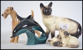 A collection of Beswick figurines to include a dog, large siamese cat, small group of siamese cats