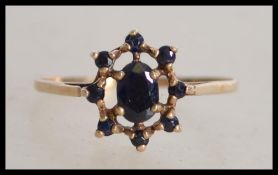 A 9ct gold and sapphire ladies ring, the central cabachon sapphire with surround sapphires, all claw
