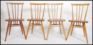 A set of 4 20th century retro Ercol spindle back dining chairs raised on turned legs with upper