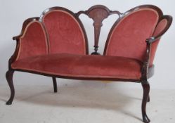 An Edwardian mahogany inlaid spoon back conversation sofa settee having shaped legs with pad feet.