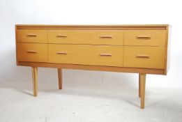 A retro 1970's mid century natural oak sideboard having tapered legs with a wide bank of 6 drawers