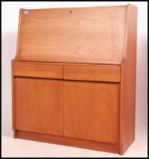 A 1970's teak wood bureau desk having fall front with appointed interior raised over single drawer