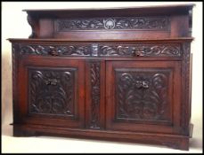 A large 19th century carved oak sideboard buffet having profusely carved doors with short drawers
