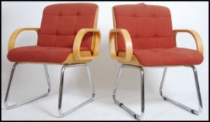 A pair of retro Eames style bentwood armchairs having bentwood show frame arms with padded seat