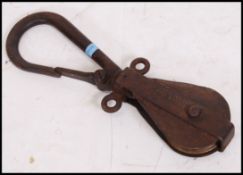 A vintage mid 20th  century  Industrial heavy cast metal industrial pulley with hook inscribed