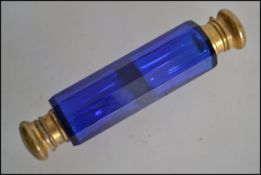 A Victorian facet cut Bristol blue glass double ended perfume bottle with unmarked  gilt metal