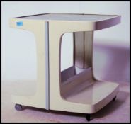 A retro 1970's white plastic Italian style occasional table having twin gallery tiers and raised