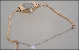 A vintage 9ct gold ladies wristwatch set to a snake linked 9ct gold bracelet complete with safety