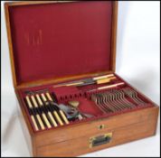 A oak canteen of cutlery, early to mid 20th century oak with brass escutcheon containing, plated,