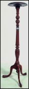A 19th century mahogany torchere with reeded support raised on tripod feet.