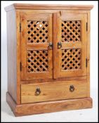 A 20th century television hardwood cabinet, having two long fret pierced doors with shelved interior