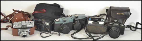 A collection of vintage cased  cameras to include 35mm examples such as Kodak, Minolta etc
