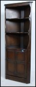 A 20th century Ercol ' Old Colonial ' beech wood corner cabinet having a qtr panel cabinet with open
