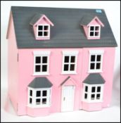 A contemporary dolls house in pink with decorative