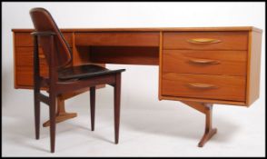 A vintage mid 20th century teak wood desk. Having a run of three drawers either side of a central