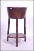 A carved oak Regency revival ice bucket - wine cooler of barrel form being raised on shaped supports