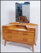 A vintage mid 20th century G Plan early Ernest Gomme blonde oak dressing table, having a series of