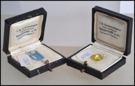 2 cased synthetic gemstones dating to the mid century by IG Farben Industrie. One emerald cut faux