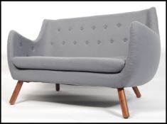 A 1950's style poet sofa in the manner of Finn Juh