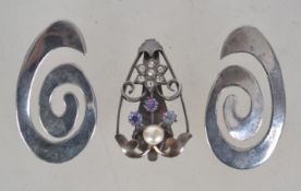 A silver dress clip with clear stone flo
