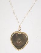 A 9ct gold pendant necklace with heart shaped 9ct back and front locket. Chain marked 9ct.