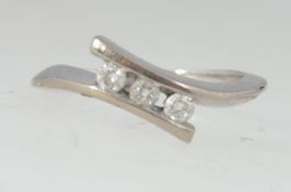 An 18 ct white gold cross over ring with 3 diamonds in total approx 7.5pts.