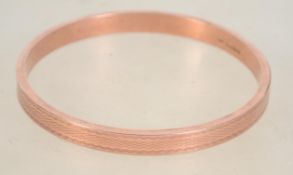 A hallmarked 9ct rose gold slave bangle bracelet.