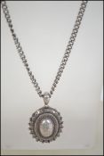 A late 19th century Victorian oval silver chase decorated mourning locket.