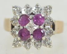 A vintage ladies 9ct gold and ruby diamond ring of cluster form having 4 round cut rubies to