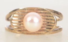 A vintage hallmarked 9ct gold and single pearl ring set with a central pearl on a scalloped lozenge