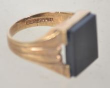 A 1970's gentlemans 9ct gold signet ring with inset square black glass stone.