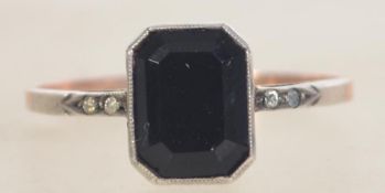 A 9ct gold and silver Art Deco ring set with a central french jet stone with paste set shoulders.