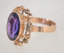 An early 20th century 15ct gold ring set with a purple oval cut stone,